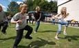Adults and children taking part in an outdoor activity at IncludFEST