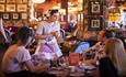 Table of 3 people being served by waitress