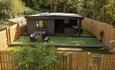 Exterior image of 'The Oak', Beamish Glamping, in a woodland location, showing the outdoor seating area.