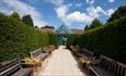 Paved walkway, seating and hedges at the Botanic Garden