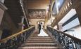 A couple on their wedding day posing on the staircase of the museum.