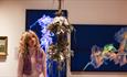 A visitor looking at a jellyfish model and portraits at The Bowes Museum - Joséphine Bowes Trendsetters and Trailblazers Exhibition