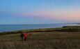 Couple walking through Easington Colliery nature reserve with coast in background