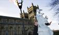 child poses with ice culture and flame lit torch outside Durham Cathedral.