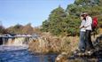 low force, two people standing on rocks, blue skies