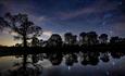 starry sky reflecting in Raby Castle lake during the night
