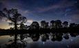 starry sky reflecting in Raby Castle lake during the night