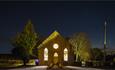 Bowlees Visitor Centre at night time with illuminated windows and starry night sky