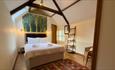 Double bedroom with high wood beams at No 1 Old Hall Cottage