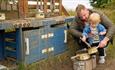 A man and boy playing a mud kitchen
