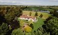 Overhead view of The Covey surrounded by tress and view of Hurworth Burn Reservoir.