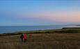 Image of a couple enjoying a walk at twilight along the Durham Heritage Coast