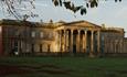 Exterior view of Wynyard Hall in Autumn with leaves on grass