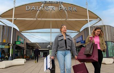 Shoppers leaving Dalton Park Outlet & Outdoors smiling.