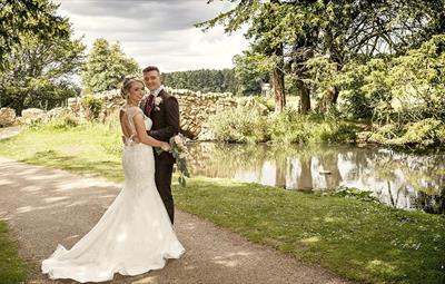Image of a couple posing for photos on their wedding day in Hardwick Park, next to Hardwick Hall Hotel