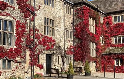 Exterior of Headlam Hall and Spa, parts covered in red autumn leaves.