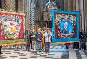 A group of people displaying Miners Banners in Durham Cathedral