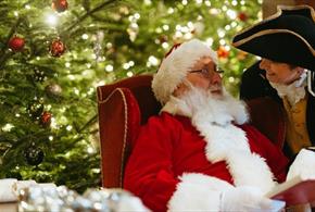 Father Christmas sitting in front of a Christmas Tree at Raby Castle