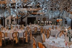 Tables and chairs dressed beautifully in white, with flowers and fairy lights,  for a wedding at South Causey Inn