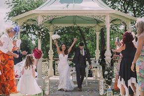 Guests throwing confetti over newly married couple.