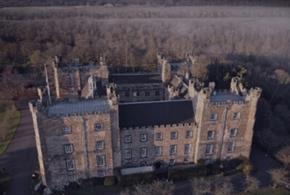 Eerie birds-eye view of Lumley Castle in fog at night.