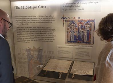 Two people looking at the 1216 Magna Carta at Durham Cathedral Museum