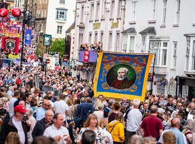 Durham Miners' Gala. Crowds enjoying the Gala outside of the County Hotel. Colliery Banners can be seen as the Bands march through the streets.