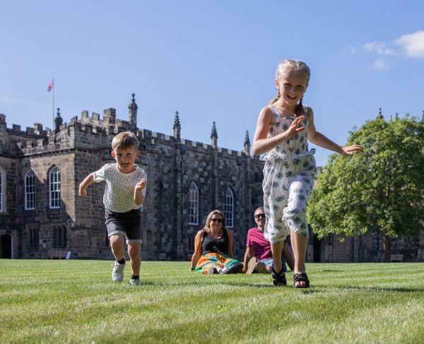 A family playing outside of Auckland Castle