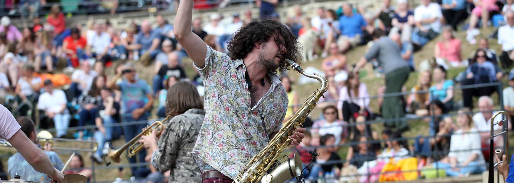 Man playing the saxophone to the crowd