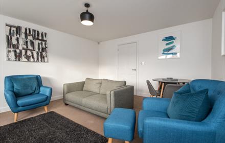 Living area with grey sofa and blue armchairs