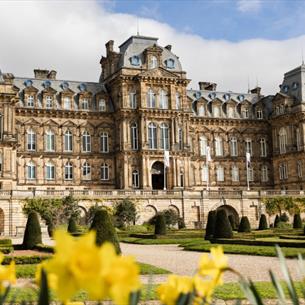 The exterior of The Bowes Museum and its grounds on a sunny day.