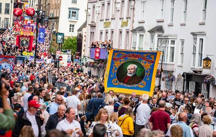Durham Miners' Gala. Crowds enjoying the Gala outside of the County Hotel. Colliery Banners can be seen as the Bands march through the streets.
