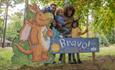 Credit: Forestry England/ Crown copyright. Image of a family enjoying the Zog trail in a forest.