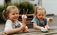 Two children eating ice creams