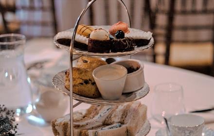 Cake stand with sandwiches, scones and cakes