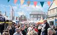 Crowds of people attending Bishop Auckland Food Festival, Market Stalls, bunting