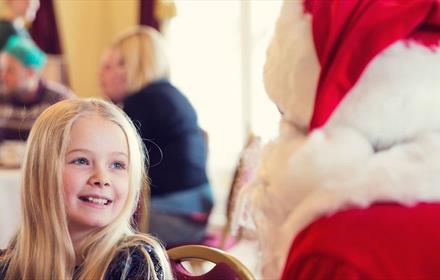 A little girl enjoys a visit to see Santa.