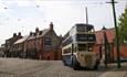 Double Decker bus parked on cobbled street in Beamish museum town.