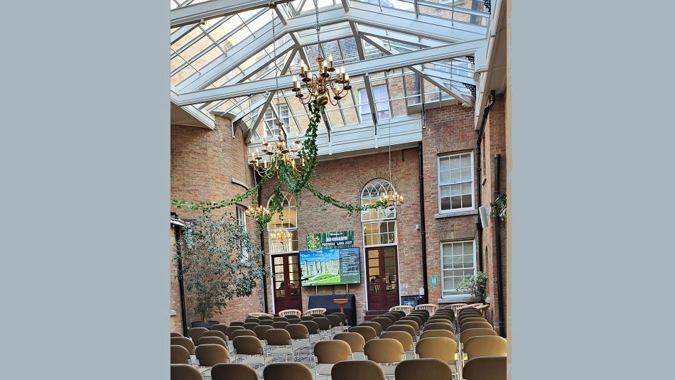 Glass ceiling room with chairs set out in Theatre style, screen