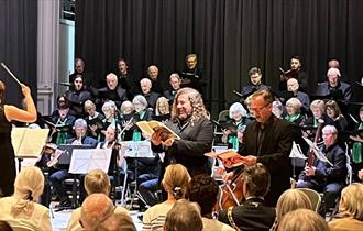 The choir sing Rossini with orchestra and conductor
