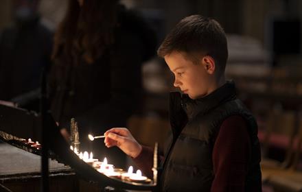 Image of a child lighting candles at Durham Cathedral.