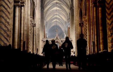 Image of silhouettes of people walking down The Nave in Durham Cathedral.