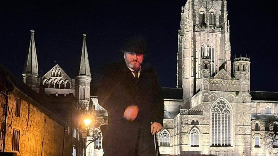 Andrew Ross (Tour guide) standing in front of Durham Cathedral on an evening