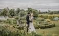Married couple standing in the gardens at Lartington Hall