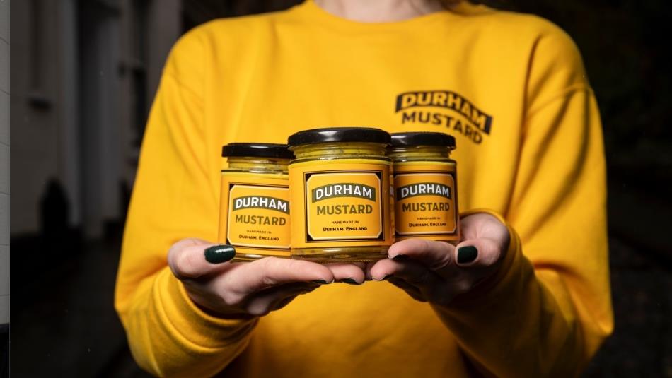 Holding 3 jars of Durham mustard in hands