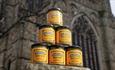 Durham mustard jars stacked on top of each other with Durham Cathedral in the background