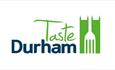 Taste Durham Logo. White background with wording in green and blue with a fork to the right of the words