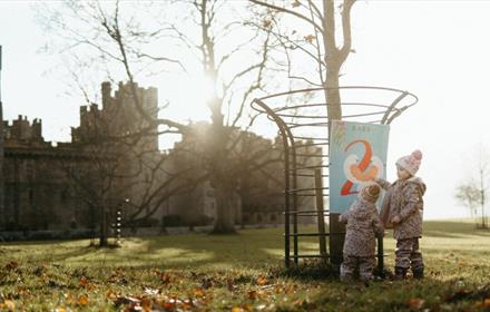 Image of two children wrapped in warm clothes in the grounds of Raby Castle.