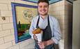 Image of a staff member holding fish and chips at Davy's Fish and Chip Shop.