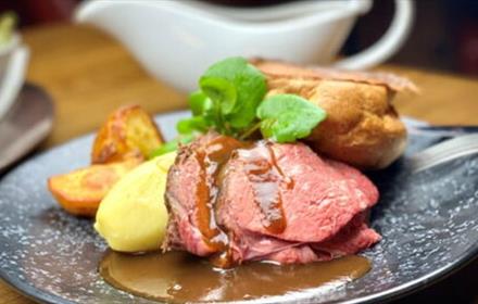 Easter Sunday Lunch at Lumley Castle, roast beef, roast potatoes, Yorkshire pudding and gravy. White gravy jug in background.